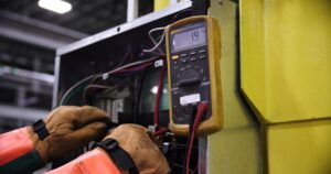 Electrician using a multimeter to diagnose wiring during a circuit repair