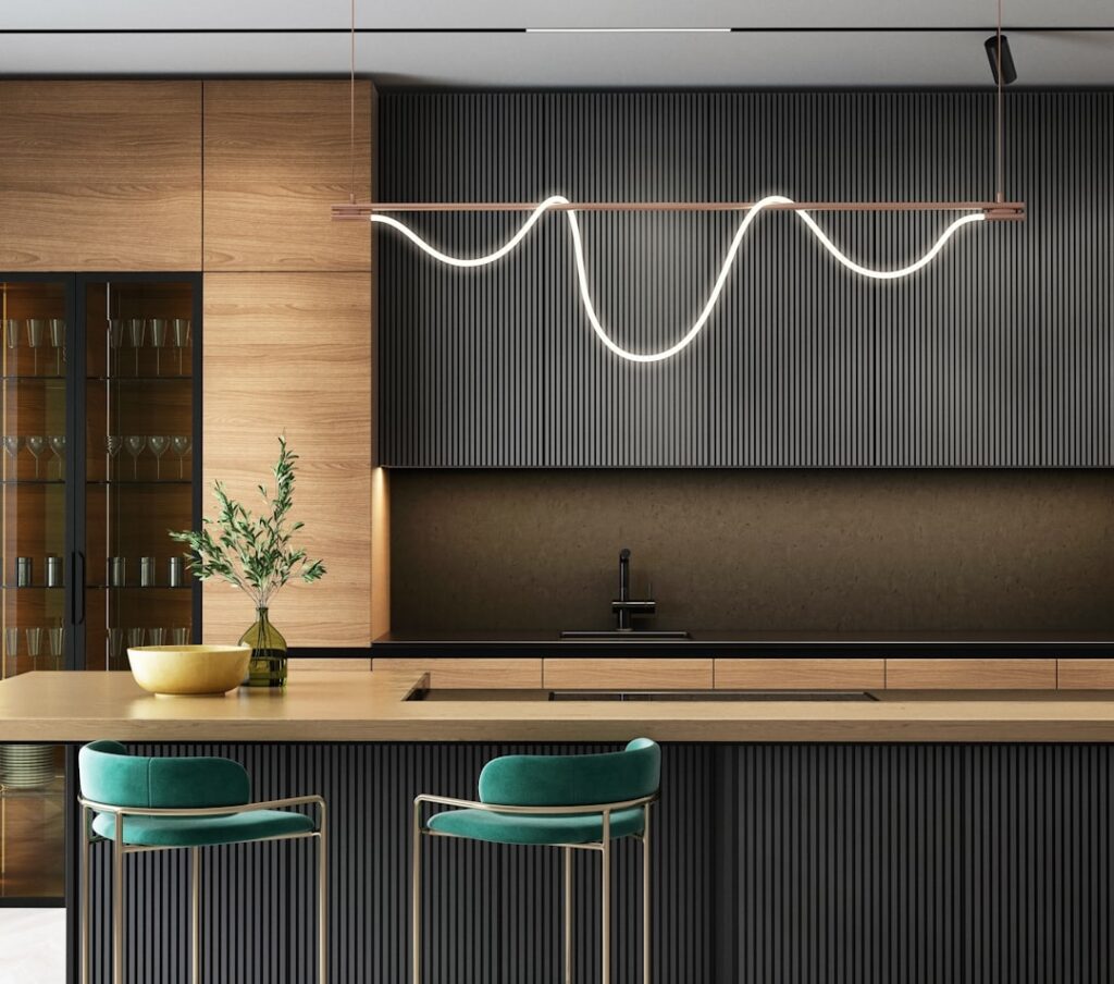 Modern kitchen with layered LED lighting including pendants, recessed lights, and bar stools